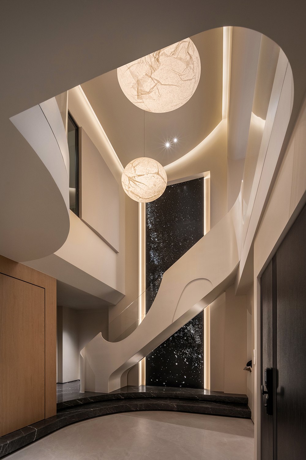 Alabaster sphere pendants over sculptural stairwell